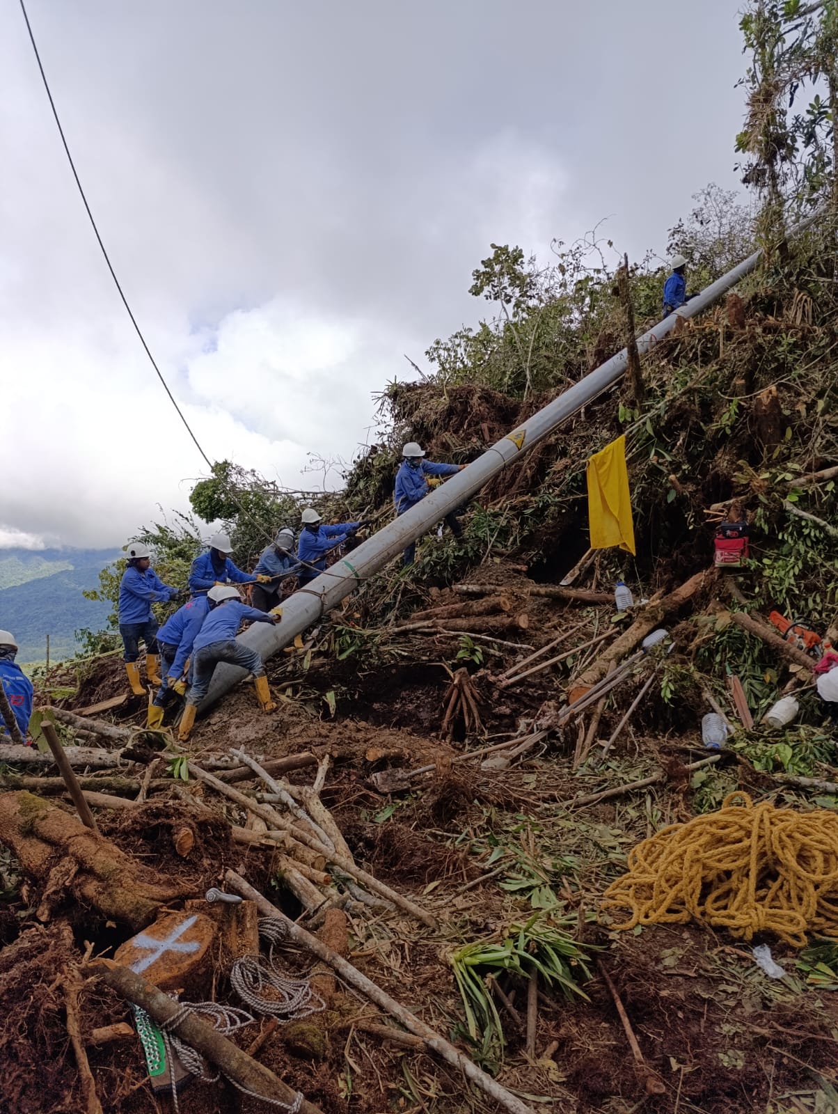Imagen de varios trabajadores levantando poste para apoyar emergencia